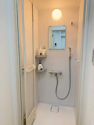 a bathroom with a shower and a mirror at PUZZLE hotel 401 in Tokyo