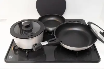 two pans sitting on top of a stove at FABRIC Nishi-Shinjuku in Tokyo