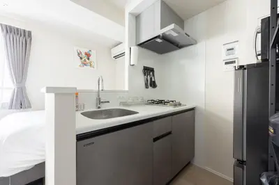 a kitchen with a sink and a refrigerator at FABRIC Nishi-Shinjuku in Tokyo