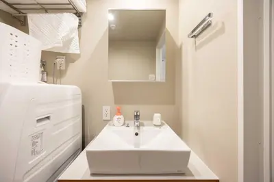 a bathroom with a white sink and a refrigerator at FABRIC Nishi-Shinjuku in Tokyo