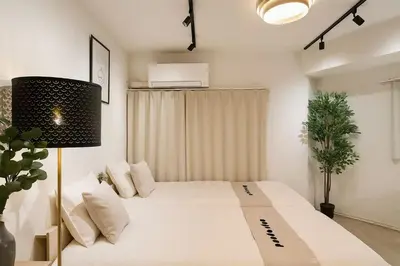a bedroom with a large white bed and a lamp at PandaStay\u521d\u53f0\u99c5,\u5f92\u6b657\u5206,\u6e0b\u8c37\u30a8\u30ea\u30a2\u8cb8\u5207\u90e8\u5c4b in Tokyo