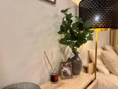 a table with a vase and a picture and a lamp at PandaStay\u521d\u53f0\u99c5,\u5f92\u6b657\u5206,\u6e0b\u8c37\u30a8\u30ea\u30a2\u8cb8\u5207\u90e8\u5c4b in Tokyo