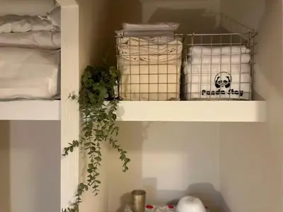 a white shelf with a potted plant in a bedroom at PandaStay\u521d\u53f0\u99c5,\u5f92\u6b657\u5206,\u6e0b\u8c37\u30a8\u30ea\u30a2\u8cb8\u5207\u90e8\u5c4b in Tokyo