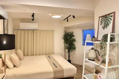 a bedroom with a bed with white sheets and a window at PandaStay\u521d\u53f0\u99c5,\u5f92\u6b657\u5206,\u6e0b\u8c37\u30a8\u30ea\u30a2\u8cb8\u5207\u90e8\u5c4b in Tokyo