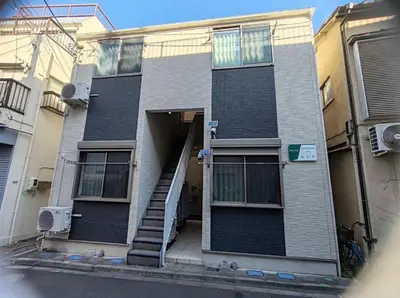 an apartment building with a staircase leading to the door at 5 min to Shinjuku, 1 min walk to Shinnakano Station, Room 102 in Tokyo