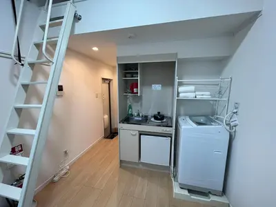 a kitchen with a staircase leading to a kitchen with a refrigerator at 5 min to Shinjuku, 1 min walk to Shinnakano Station, Room 102 in Tokyo