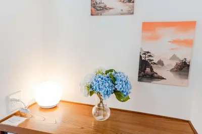 a vase with blue flowers sitting on a table at 102Room,Free parking just a 7-minute walk from Koiwa tram stop This spacious 75-square-meter flats features two large bedrooms and can accommodate up to seven guests in Tokyo