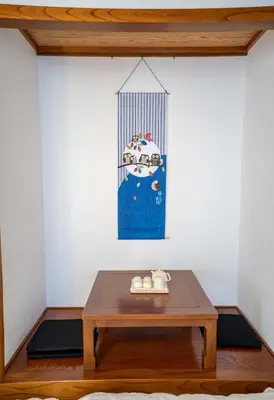 a coffee table in a room with a painting of a cow at 102Room,Free parking just a 7-minute walk from Koiwa tram stop This spacious 75-square-meter flats features two large bedrooms and can accommodate up to seven guests in Tokyo