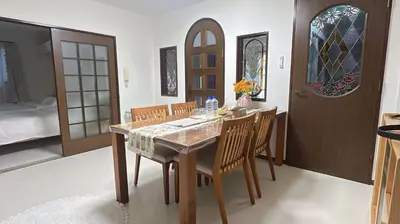 a dining room with a table with chairs and stained glass windows at 102Room,Free parking just a 7-minute walk from Koiwa tram stop This spacious 75-square-meter flats features two large bedrooms and can accommodate up to seven guests in Tokyo
