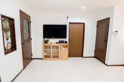 a room with two doors and a tv on the wall at 102Room,Free parking just a 7-minute walk from Koiwa tram stop This spacious 75-square-meter flats features two large bedrooms and can accommodate up to seven guests in Tokyo