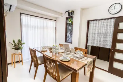 a dining room with a table and chairs and a clock at 102Room,Free parking just a 7-minute walk from Koiwa tram stop This spacious 75-square-meter flats features two large bedrooms and can accommodate up to seven guests in Tokyo