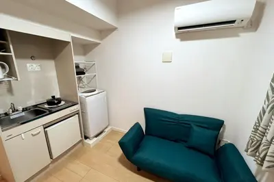 a small kitchen with a blue chair in a room at Shinjuku 5 min, 1 min walk from Shinnakano Station, Room 202 in Tokyo