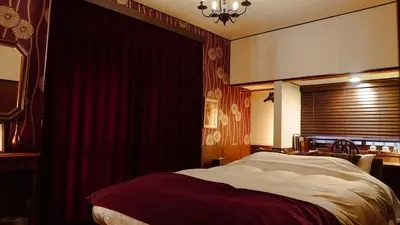 a bedroom with a bed and a red curtain at Chronos House Tokyo Kitasenju - Time Travel Stay in Tokyo
