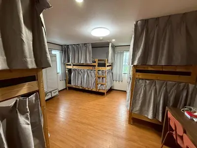 a room with wooden floors and a room with bunk beds at Male-only dormitory Tokyo House INN in Tokyo