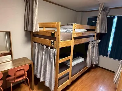 a room with two bunk beds with a table and a tableablish at Male-only dormitory Tokyo House INN in Tokyo
