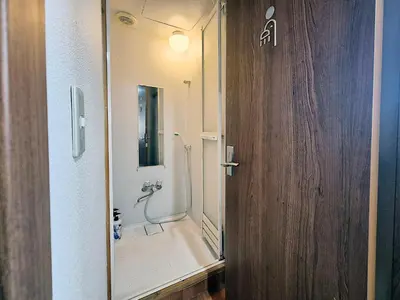 a bathroom with a shower with a glass door at Male-only dormitory Tokyo House INN in Tokyo