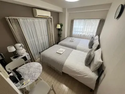 a bedroom with a bed and a table and a chair at \u6e0b\u8c37\u533a\u3067\u306e\u5bbf\u6cca\u65bd\u8a2d \u99c5\u304b\u30893\u5206 in Tokyo