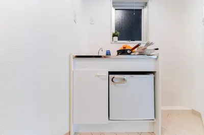 a white kitchen with a sink and a dishwasher at \u6e0b\u8c37\u533a\u3067\u306e\u5bbf\u6cca\u65bd\u8a2d \u99c5\u304b\u30893\u5206 in Tokyo