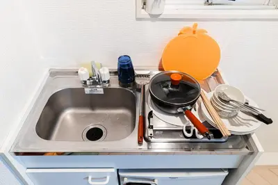 a kitchen sink with a frying pan and utensils at \u6e0b\u8c37\u533a\u3067\u306e\u5bbf\u6cca\u65bd\u8a2d \u99c5\u304b\u30893\u5206 in Tokyo