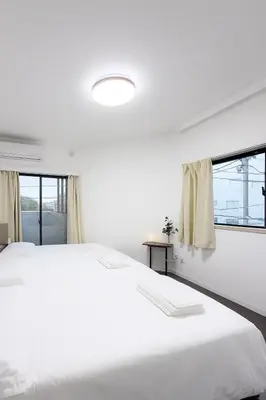 a white bedroom with a large bed and windows at Ojihoncho301 Triple Room in Tokyo