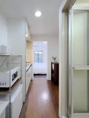 a kitchen with a microwave and a bed in a room at Ojihoncho301 Triple Room in Tokyo