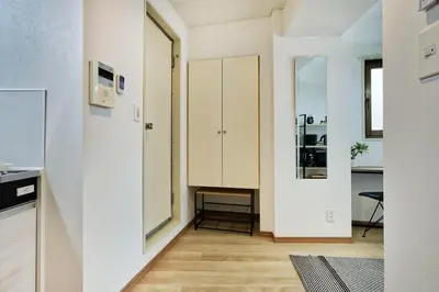 a kitchen with white cabinets and a wooden floor at CraftFlat Komagome 509, a compact studio at excellent location in Tokyo