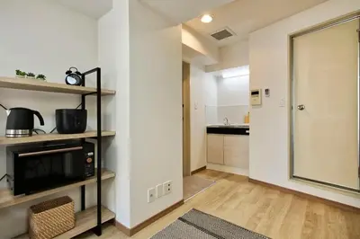 a living room with a kitchen and a large glass door at CraftFlat Komagome 509, a compact studio at excellent location in Tokyo