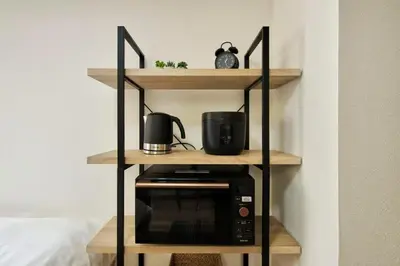 a shelf with a microwave on top of it at CraftFlat Komagome 509, a compact studio at excellent location in Tokyo
