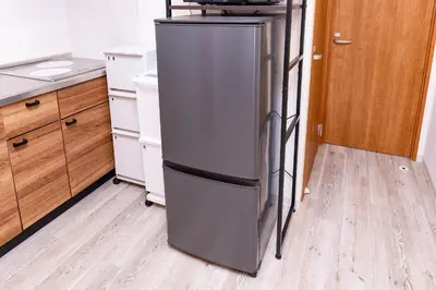a kitchen with a stainless steel refrigerator in a kitchen at Shinjuku Nakai House in Tokyo
