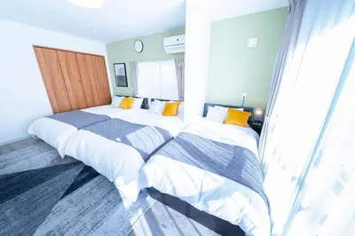 a bedroom with two beds and a window at Shinjuku Nakai House in Tokyo