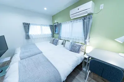 a small room with a bed and a desk and a desk at Shinjuku Nakai House in Tokyo