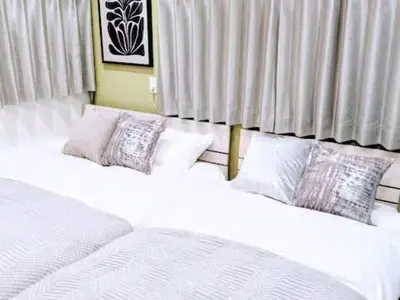 two beds sitting next to each other in a bedroom at Shinjuku Nakai House in Tokyo