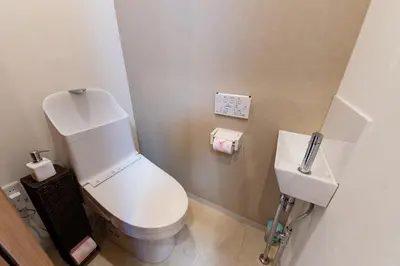 a bathroom with a white toilet and a sink at Shinjuku Nakai House in Tokyo
