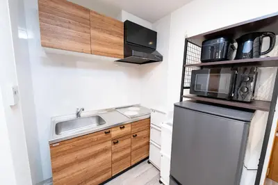 a small kitchen with a sink and a microwave at Shinjuku Nakai House in Tokyo