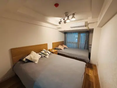 two beds in a small room with a window at \u30e9\u30a4\u30aa\u30f3\u30ba\u30d7\u30e9\u30b6\u65b0\u5bbf1002 in Tokyo