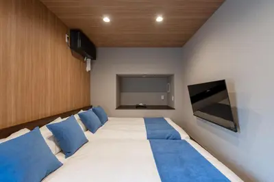 a bedroom with a large bed with blue pillows at Newly Opened \u6c60\u888b\u30c6\u30e9\u30b9\u30cf\u30a6\u30b9B in Tokyo