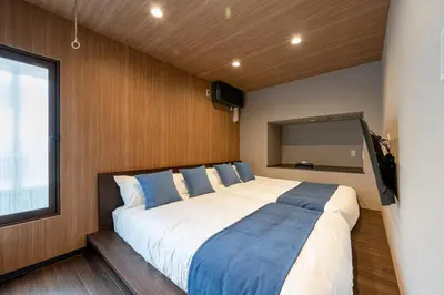 a bedroom with a large bed with blue and white pillows at Newly Opened \u6c60\u888b\u30c6\u30e9\u30b9\u30cf\u30a6\u30b9B in Tokyo