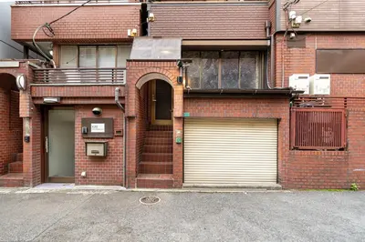 a brick house with two garage doors on a street at Newly Opened \u6c60\u888b\u30c6\u30e9\u30b9\u30cf\u30a6\u30b9B in Tokyo
