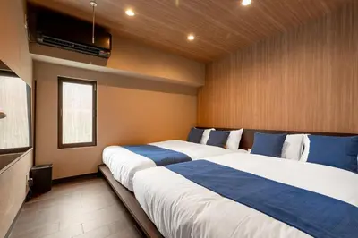 a bedroom with two beds with blue and white sheets at Newly Opened \u6c60\u888b\u30c6\u30e9\u30b9\u30cf\u30a6\u30b9B in Tokyo