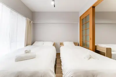 two beds in a room with white sheets at Ohana's 2rooms Walk to Shibuya station by 8 minutes apartment studio MAX10 in Tokyo