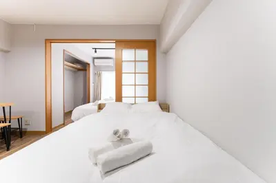 a white bed with two towels on top of it at Ohana's 2rooms Walk to Shibuya station by 8 minutes apartment studio MAX10 in Tokyo