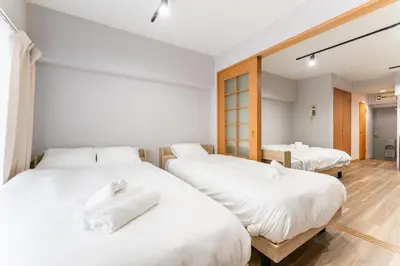 two beds in a room with white sheets at Ohana's 2rooms Walk to Shibuya station by 8 minutes apartment studio MAX10 in Tokyo