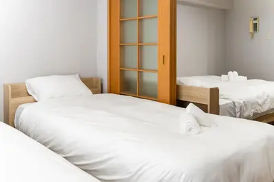 two beds in a room with white sheets at Ohana's 2rooms Walk to Shibuya station by 8 minutes apartment studio MAX10 in Tokyo