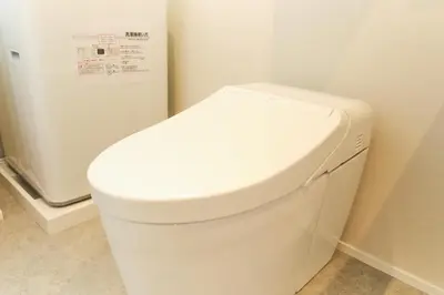 a white toilet in a bathroom with a refrigerator at monthly U Place Shimokitazawa in Tokyo