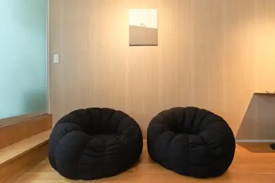 two black ottoman chairs sitting in a room at monthly U Place Shimokitazawa in Tokyo