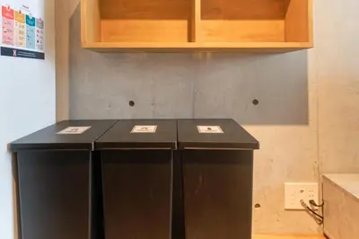 two black refrigerators in a kitchen with wooden cabinets at monthly U Place Shimokitazawa in Tokyo