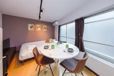 a room with a bed and a table and chairs at monthly TS Yoyogi in Tokyo