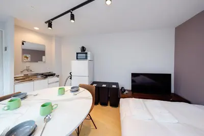a living room with a white table and a kitchen at monthly TS Yoyogi in Tokyo