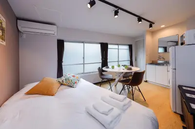 a bedroom with a large white bed and a table at monthly TS Yoyogi in Tokyo