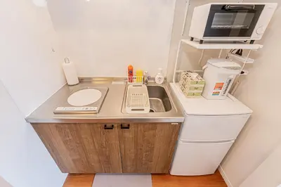 a small kitchen with a sink and a microwave at KAKURE Yahiro 3-Chome New 2LDK House,Washer-Dryer & Free Parking,1 Stop to Skytree in Tokyo